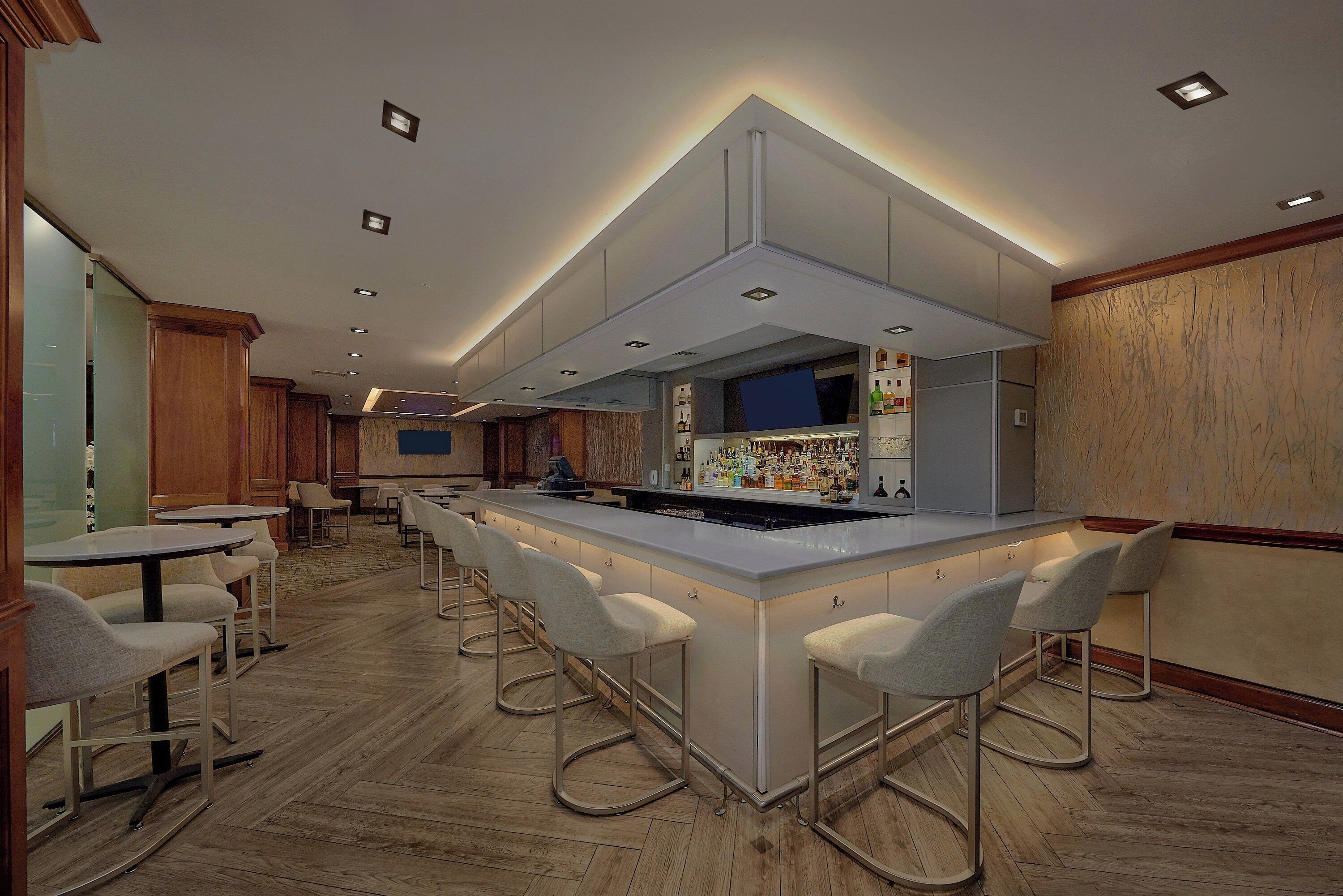 Une cuisine moderne dotée d’un îlot central, de tabourets de bar et d’un coin bar.
