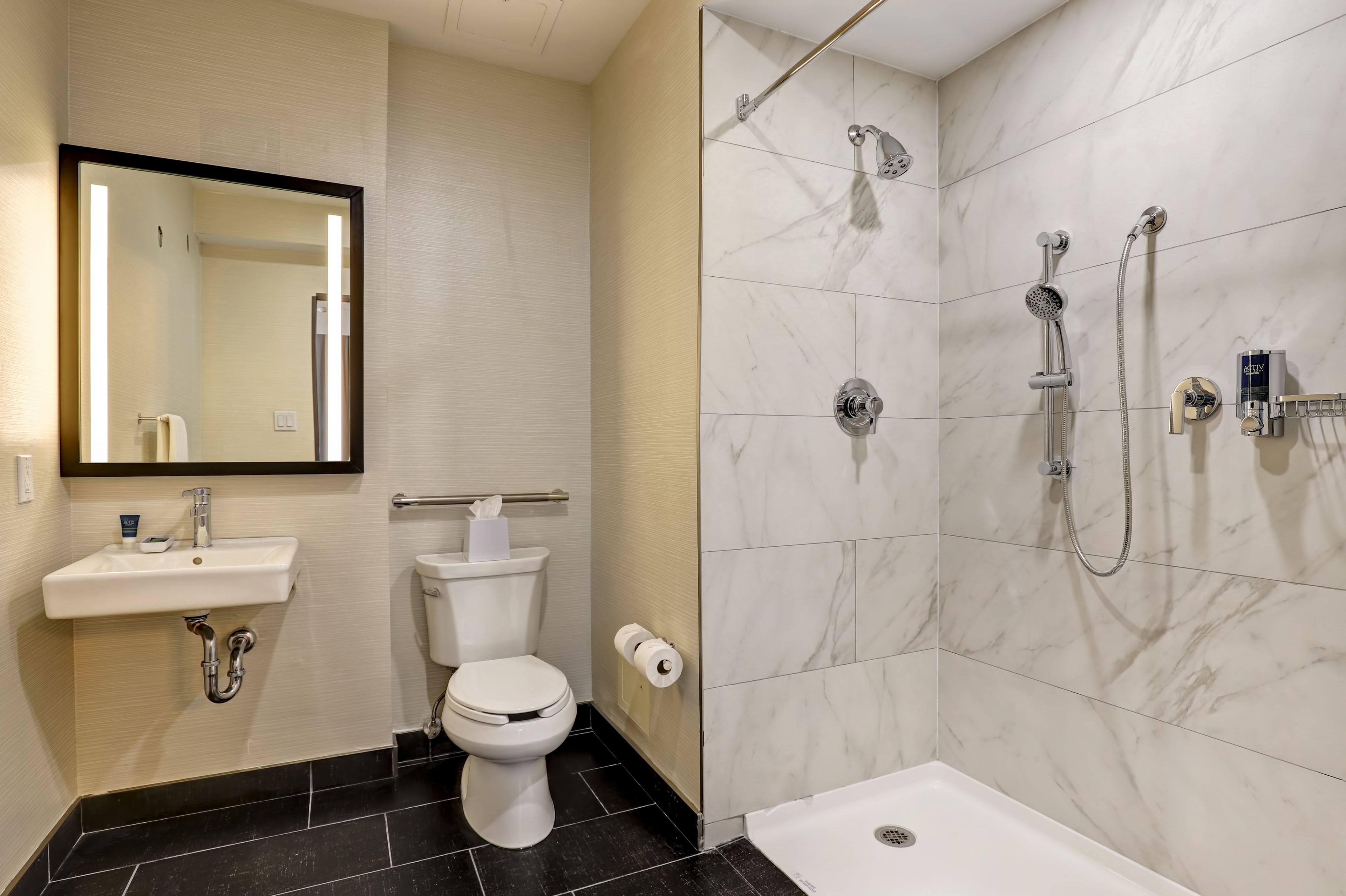 Un baño moderno con inodoro, lavamanos y ducha.