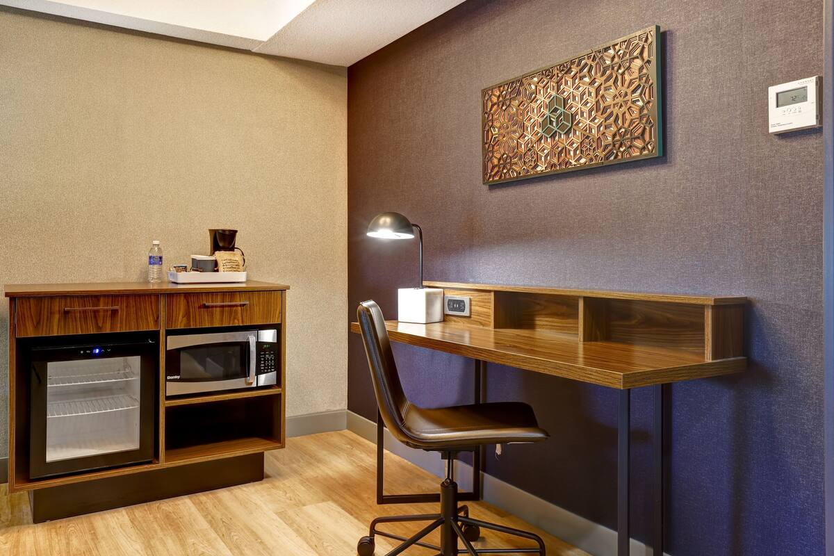 A compact kitchenette with a microwave, oven, and coffee maker.