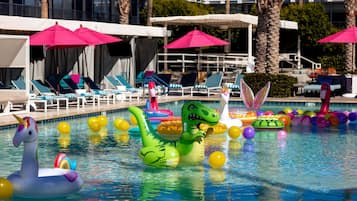 Relax by the pool surrounded by palm trees and lounge under the shade of an umbrella.