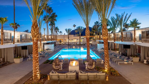 A pool area with lounge chairs, a fire feature, and palm trees. - Hotel Adeline, Scottsdale, a Tribute Portfolio Hotel (Scottsdale)