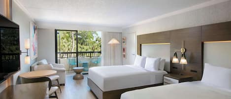 A modern hotel room with two beds, a dining area, and a balcony with a view of greenery.