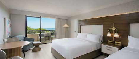 A hotel room with a large bed, a desk, a chair, and a view of the outdoors.