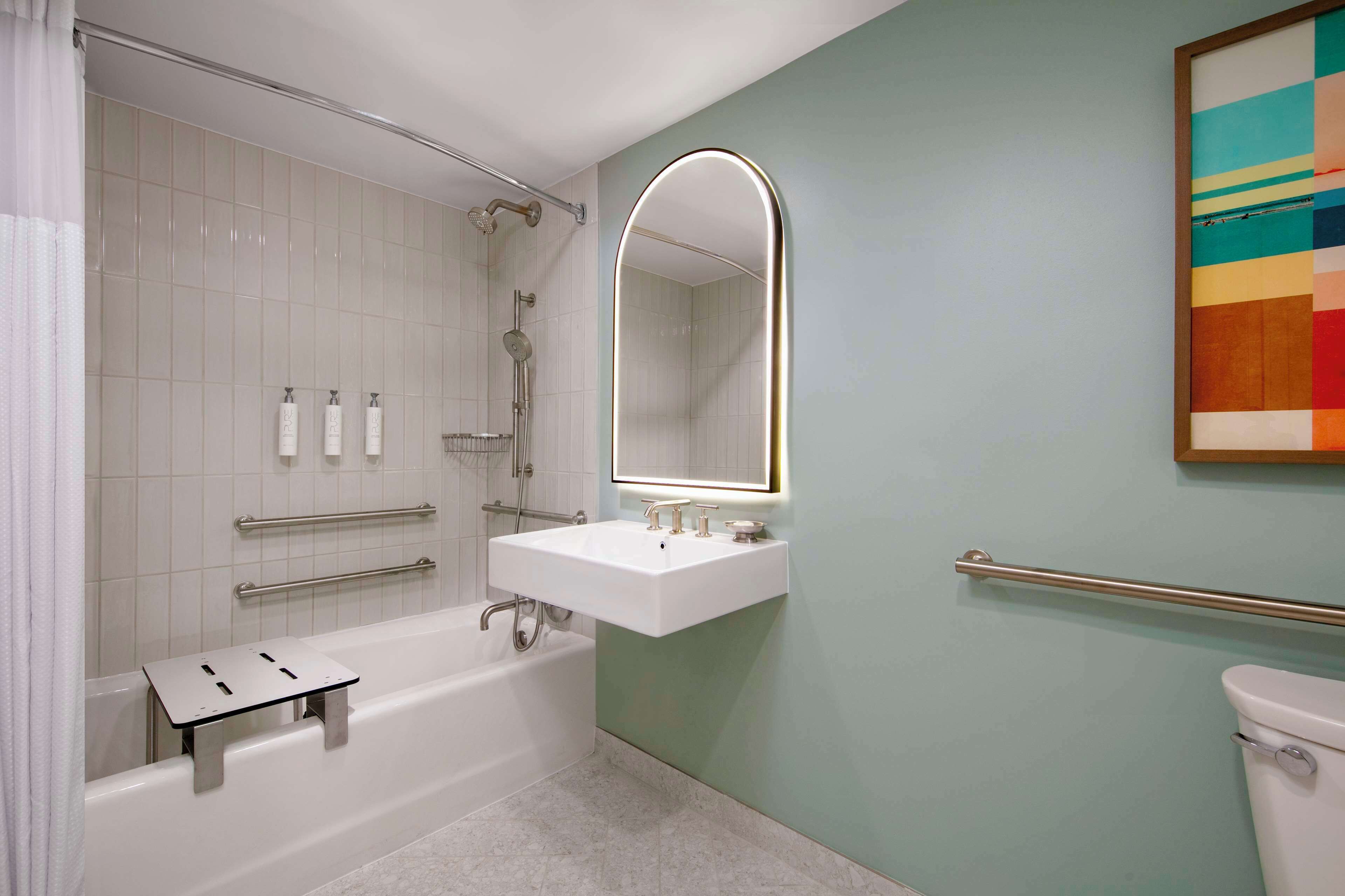 Une salle de bain moderne équipée d’une baignoire, d’une douche et d’un lavabo.
