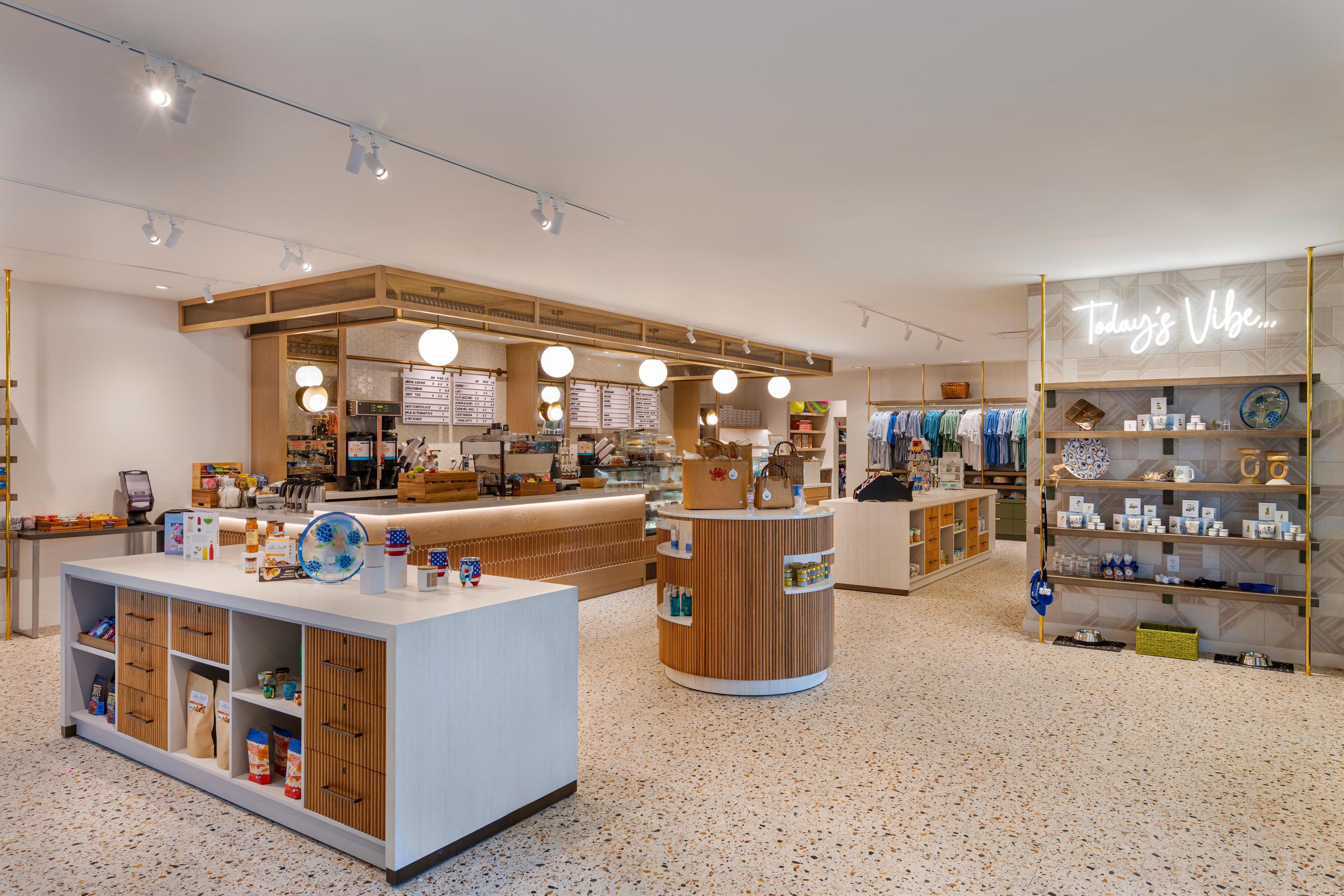 Een moderne winkel met een centraal loket, houten displayplanken en een neonbord.