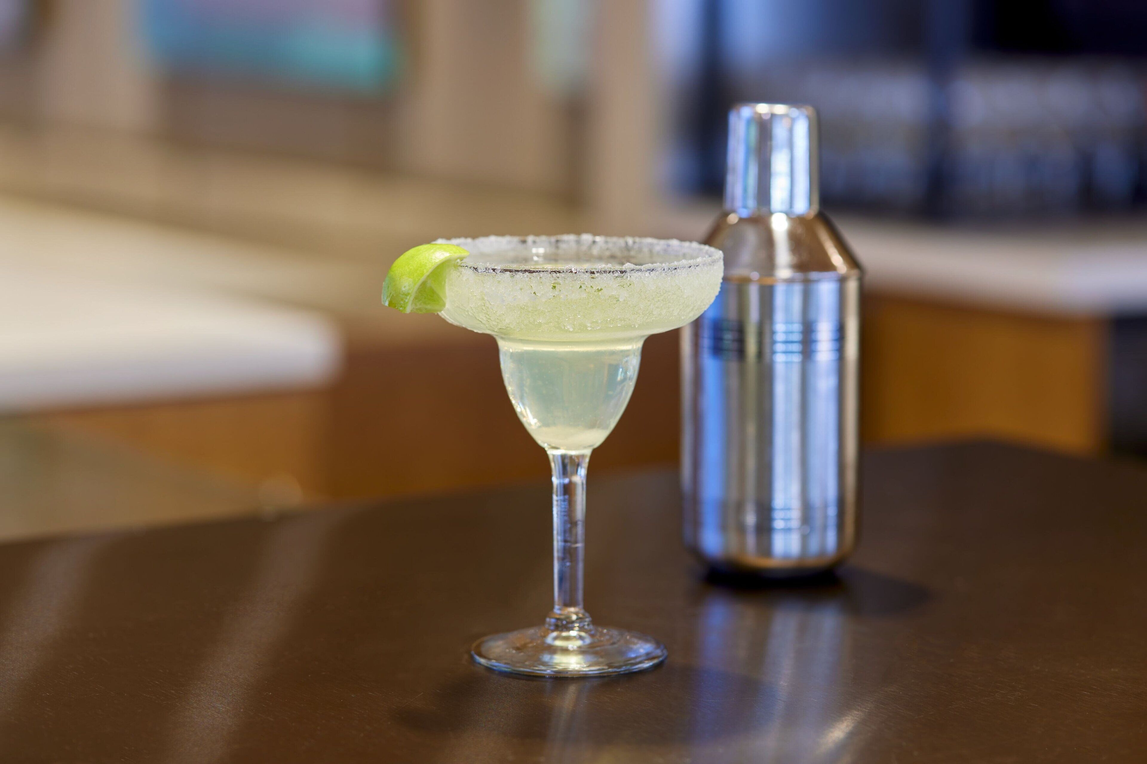 A margarita glass with a lime garnish on a table.