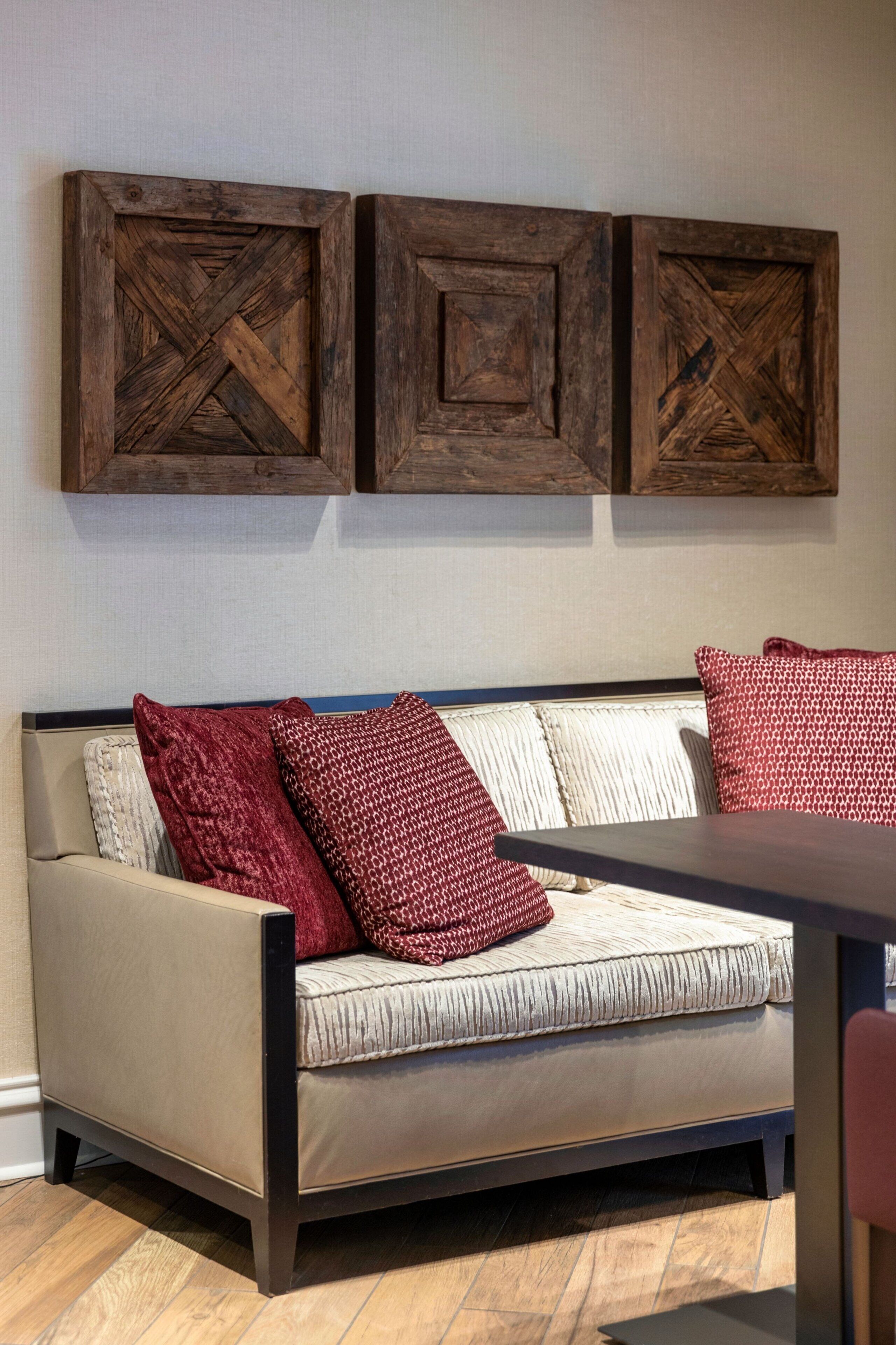 A sofa with a patterned cushion and a wooden coffee table.