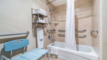 A bathroom with a shower, a bathtub, a toilet, and a wheelchair-accessible bench.