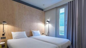 A hotel room with two beds, a window with blinds, a lamp, and a small table. - ibis Styles Paris Place d'Italie Butte aux Cailles Hotel (Paris)