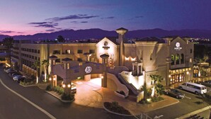 A hotel with a central courtyard, multiple buildings, and a mountain backdrop. - DoubleTree by Hilton Los Angeles - Rosemead (Montebello)