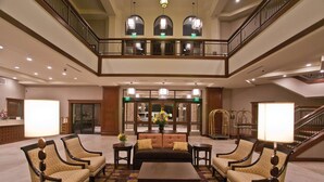 A spacious lobby with a central seating area, a staircase, and a view of the entrance. - DoubleTree by Hilton Los Angeles - Rosemead (Montebello)