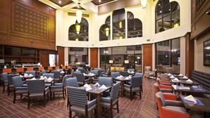 A spacious restaurant with high ceilings, large windows, and a variety of seating options including tables and booths. - DoubleTree by Hilton Los Angeles - Rosemead (Montebello)
