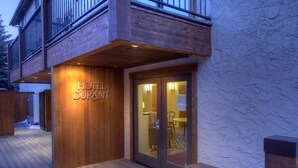 A wooden exterior of a hotel with a sign reading "HOTEL DURANT". - Hotel Durant (Aspen)