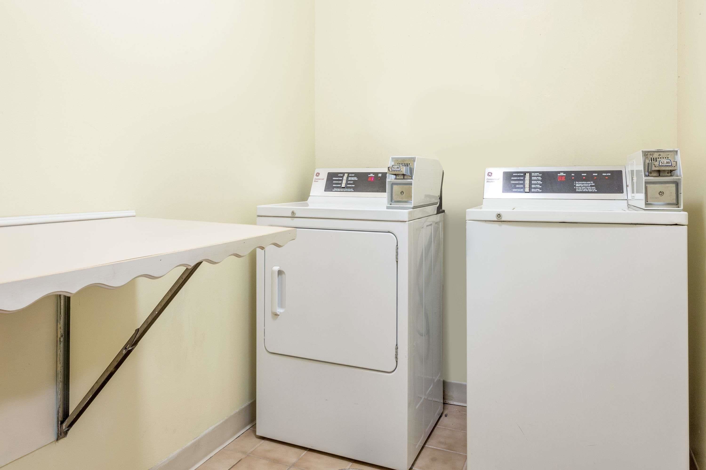 A laundry area with two white washing machines and a white table.
