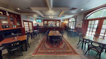 A restaurant with a bar area, multiple tables, and chairs.