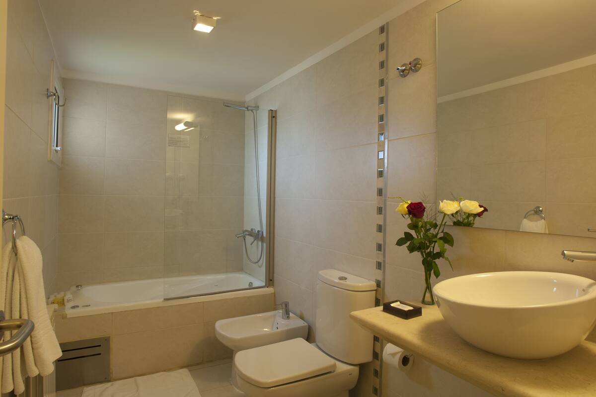A modern bathroom with a bathtub, toilet, and sink.