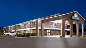 A Days Inn with a brick facade, multiple balconies, and a parking lot.