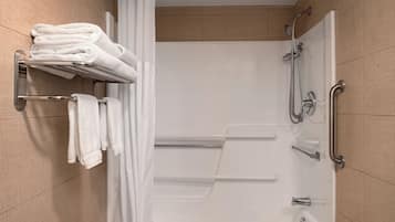 A modern bathroom with a shower, a towel rack, and a handrail.