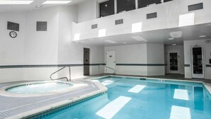 A large indoor swimming pool with a hot tub, tiled walls, and a clock on the wall. - Comfort Inn Bellingham (Bellingham)