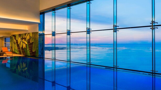Ein modernes Interieur mit einem Glasboden, der einen Blick auf den Ozean freigibt.