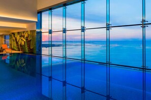 A modern interior with a glass floor leading to a view of the ocean.