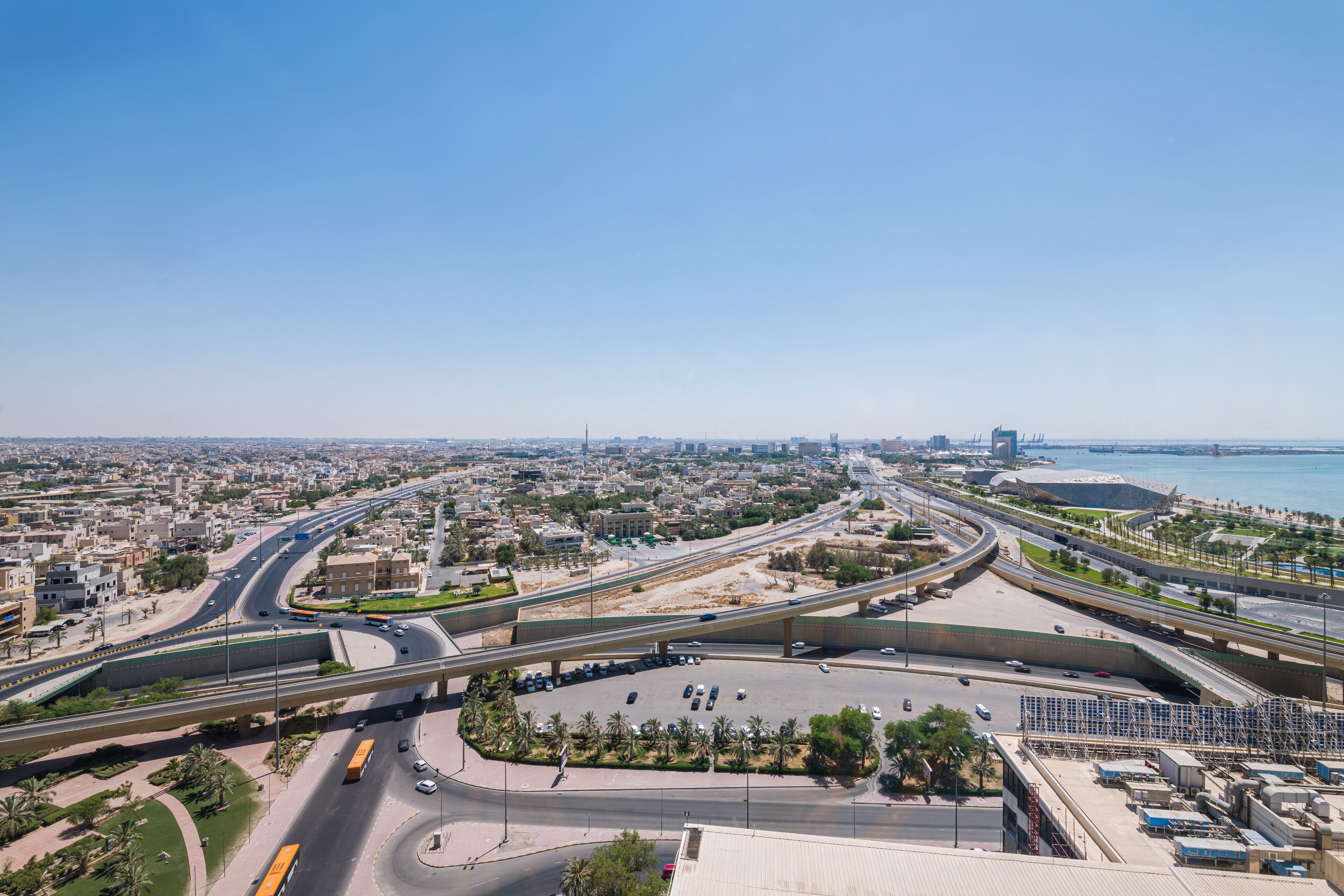 A multi-level highway interchange with overpasses and a parking area.