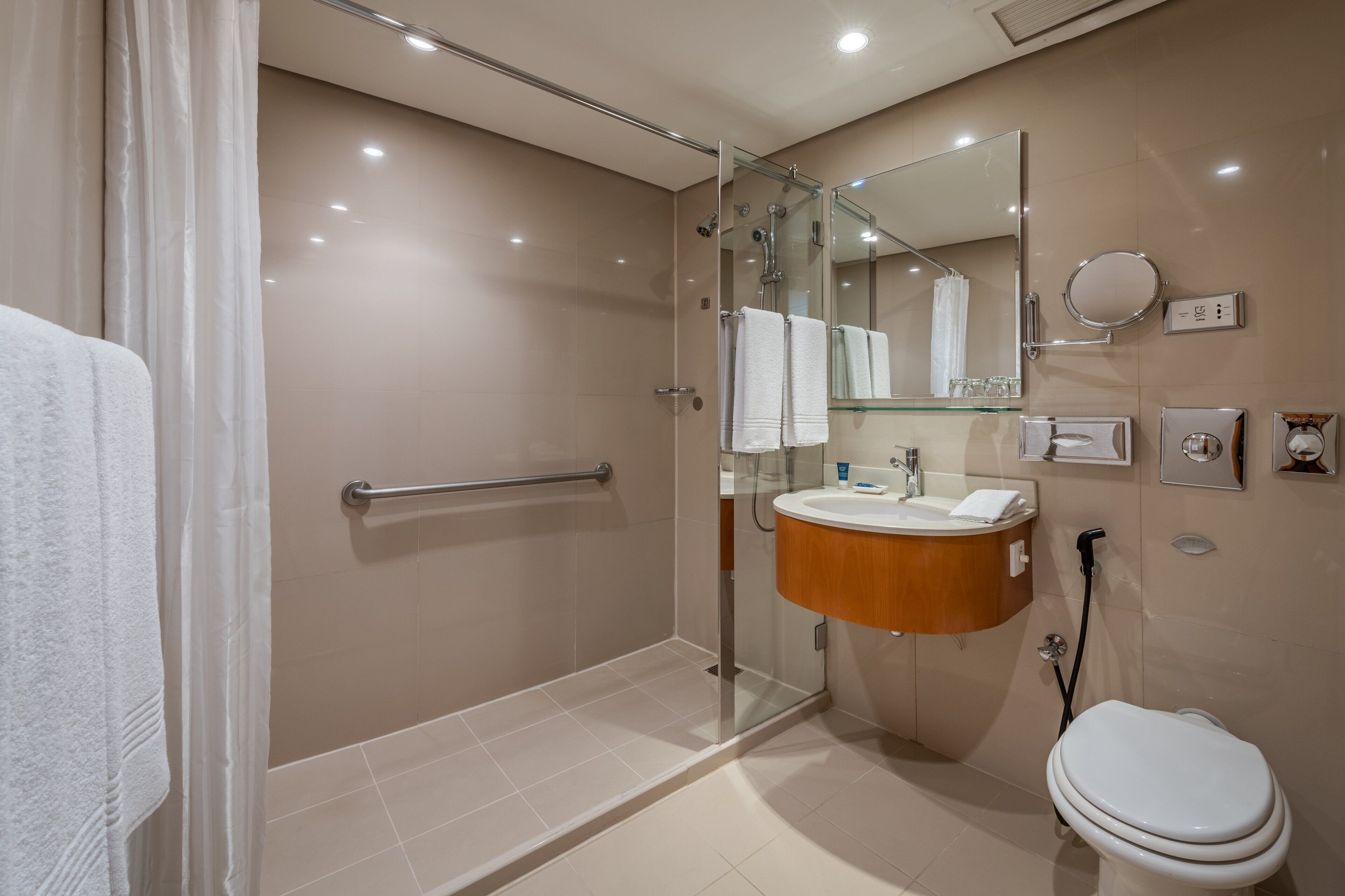 A modern bathroom with a glass-enclosed shower, a vanity with a sink, and a toilet.