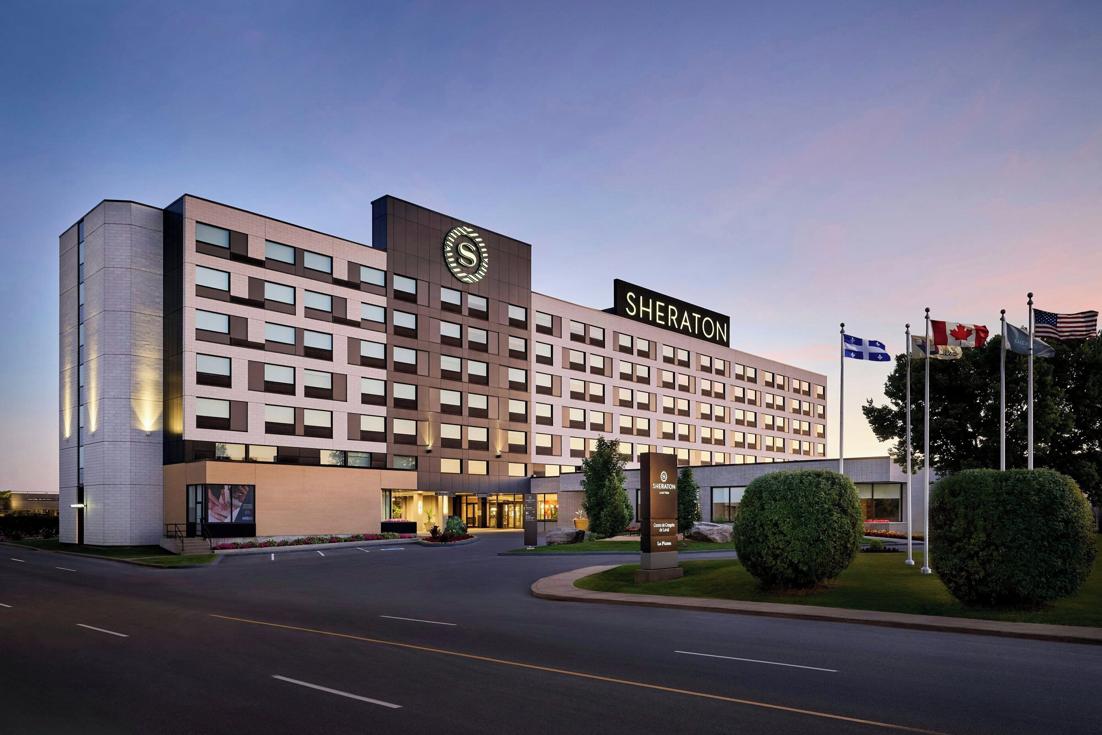 Ein Sheraton Hotel im modernen Stil, mit einer großen Schilder mit dem Sheraton-Logo und -Namen.