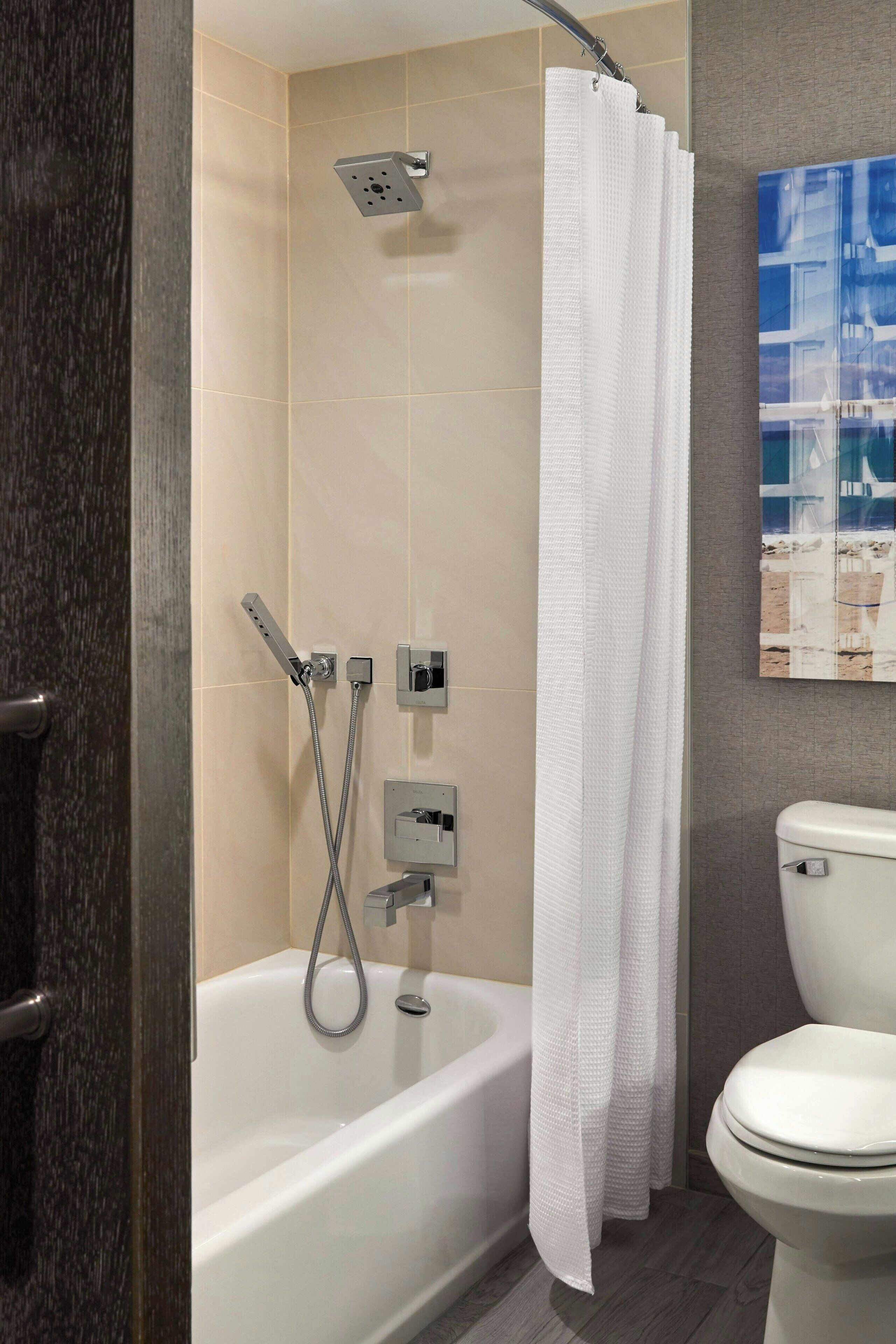Un baño con bañera, ducha e inodoro.