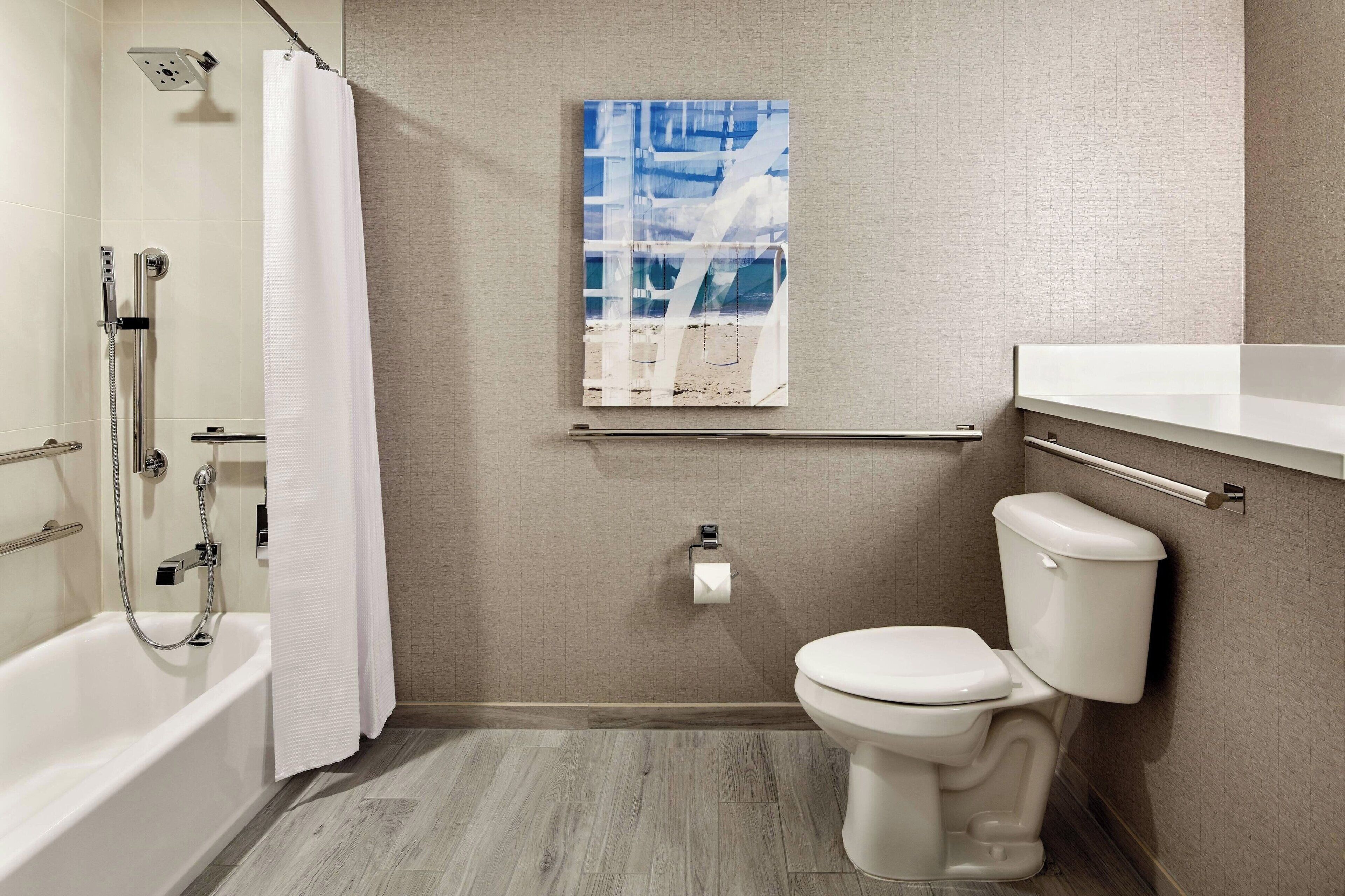 A bathroom with a shower, toilet, and a towel rack.