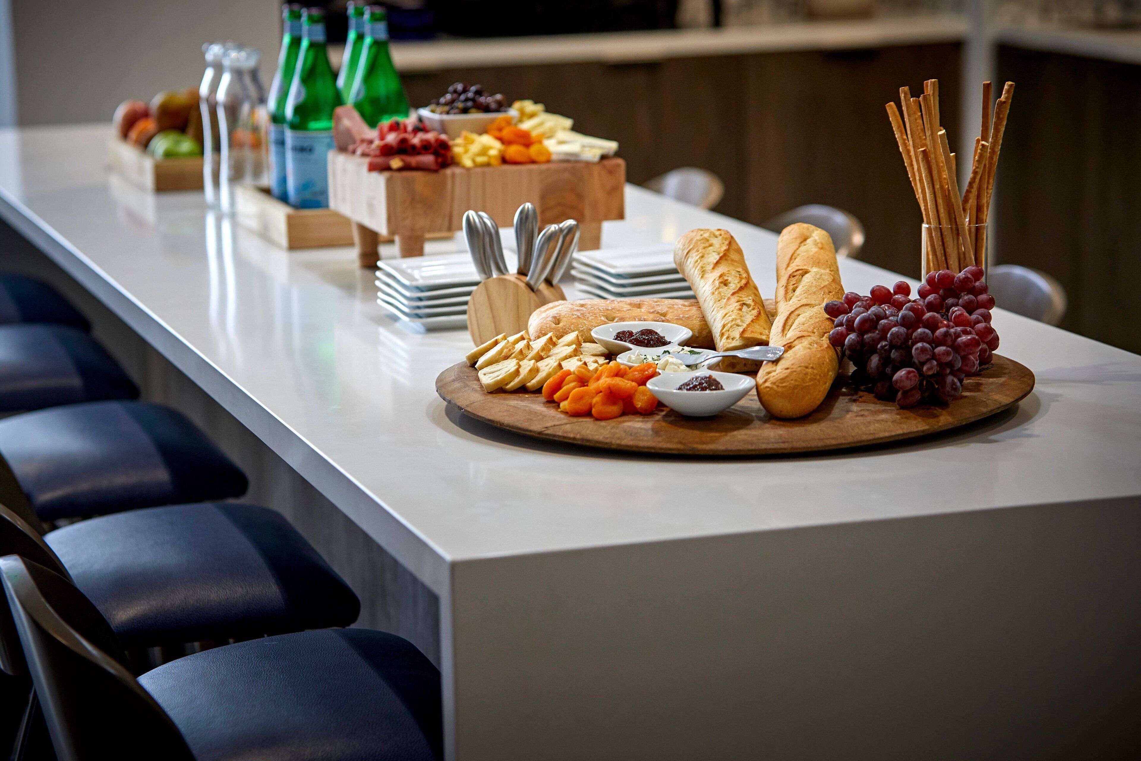 Een buffet met verschillende kazen, fruit en brood.