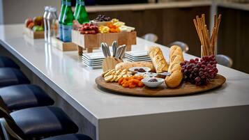 Een buffet met verschillende kazen, fruit en brood.