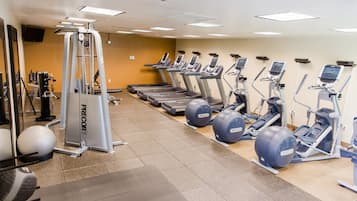 A gym with treadmills, elliptical machines, and a weight machine.