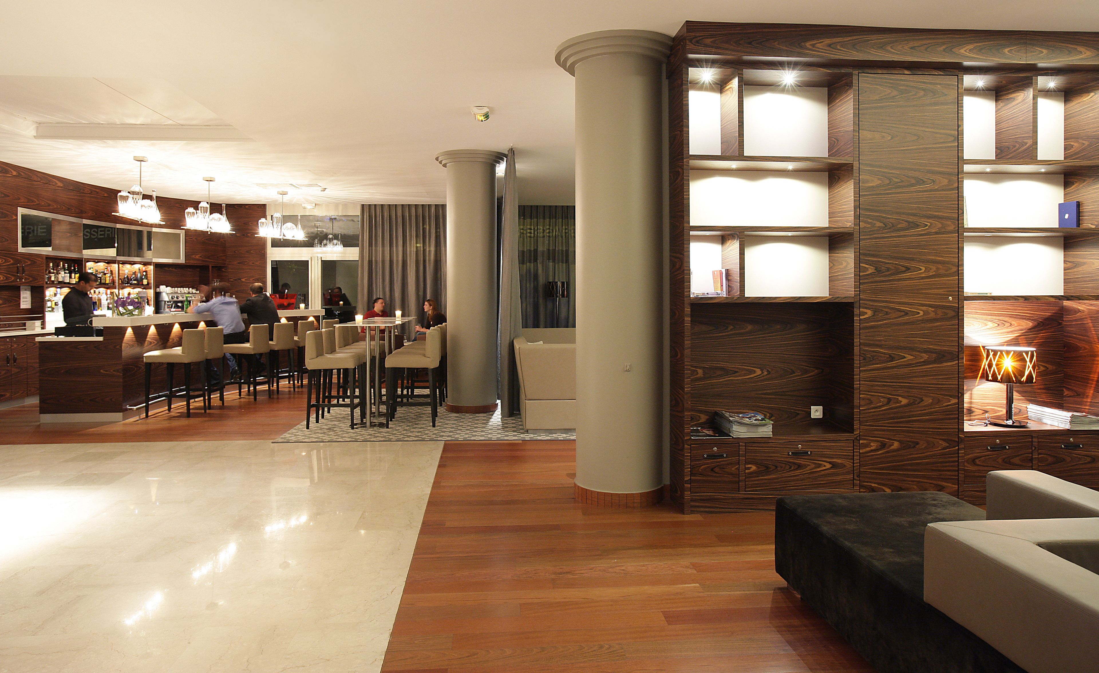 A hotel lobby with a bar area, seating, and a reception desk.