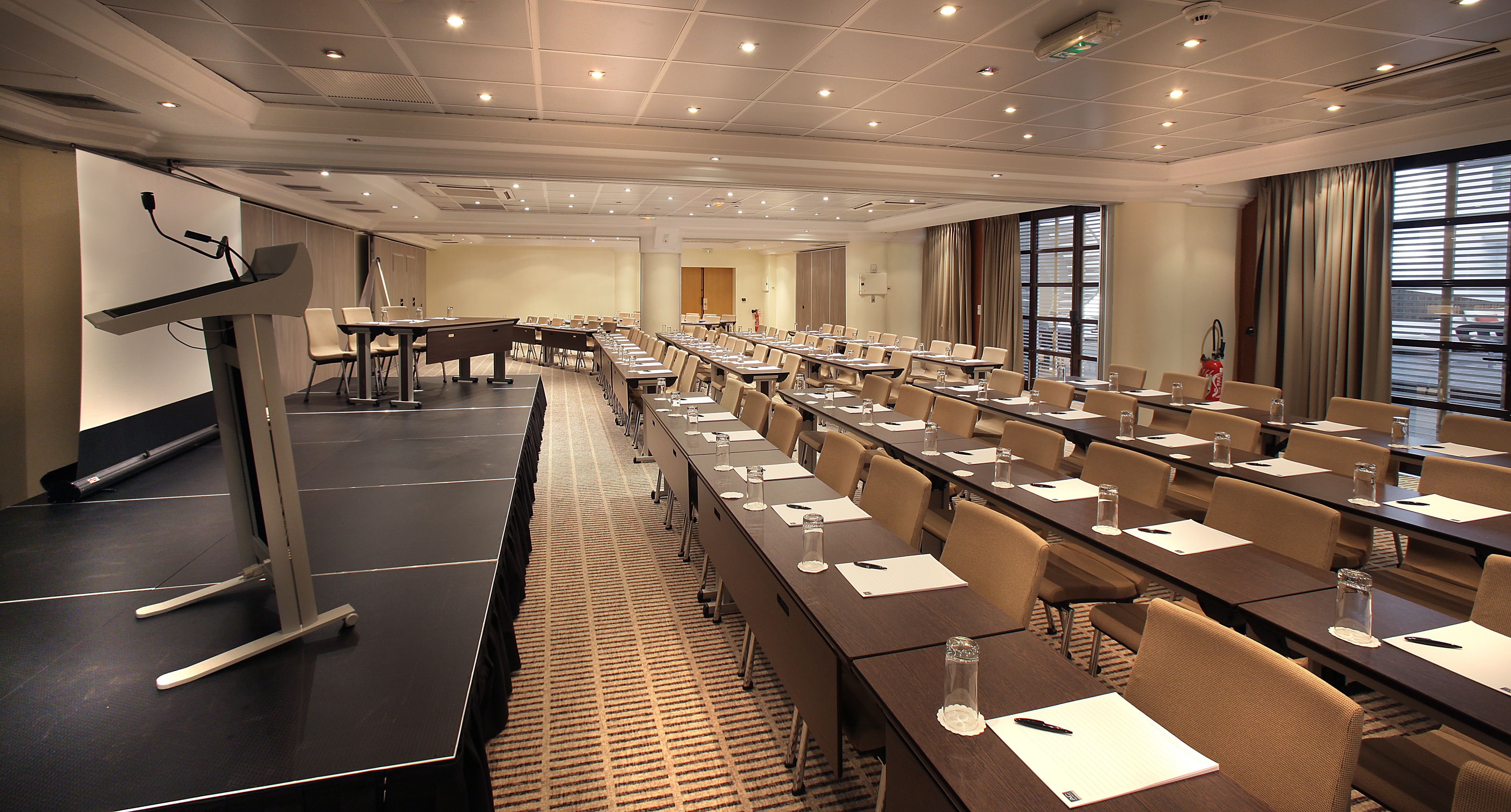 A conference room with a long table, chairs, and a podium.