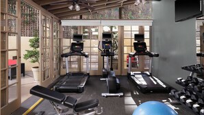 Un gimnasio con cintas de correr, elípticas y pesas sueltas.