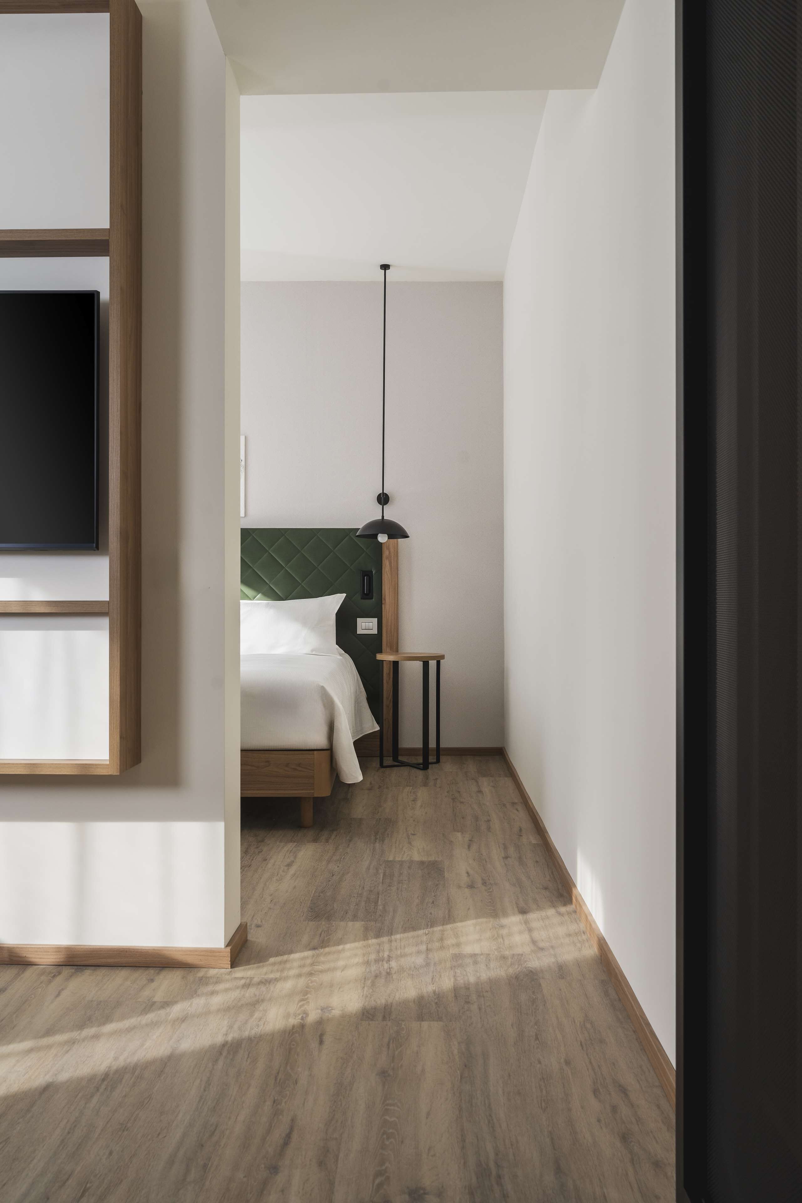 Ein Schlafzimmer mit Bett, Nachttisch und einer Hängelampe.