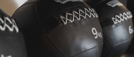 A close-up of black exercise balls with "TECHNICA" and "9kg" labels.