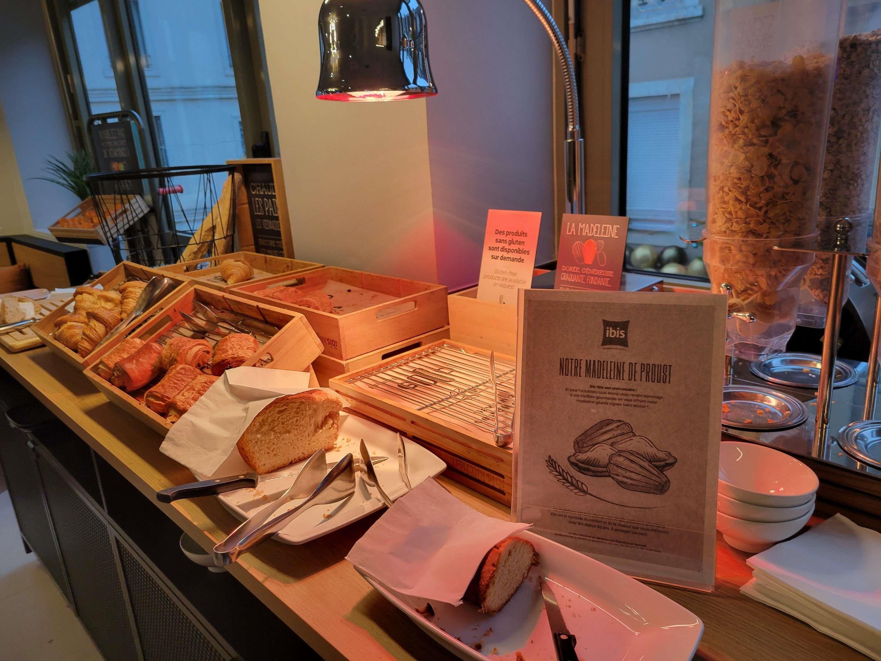 A buffet with various food items, utensils, and a sign indicating gluten-free options.