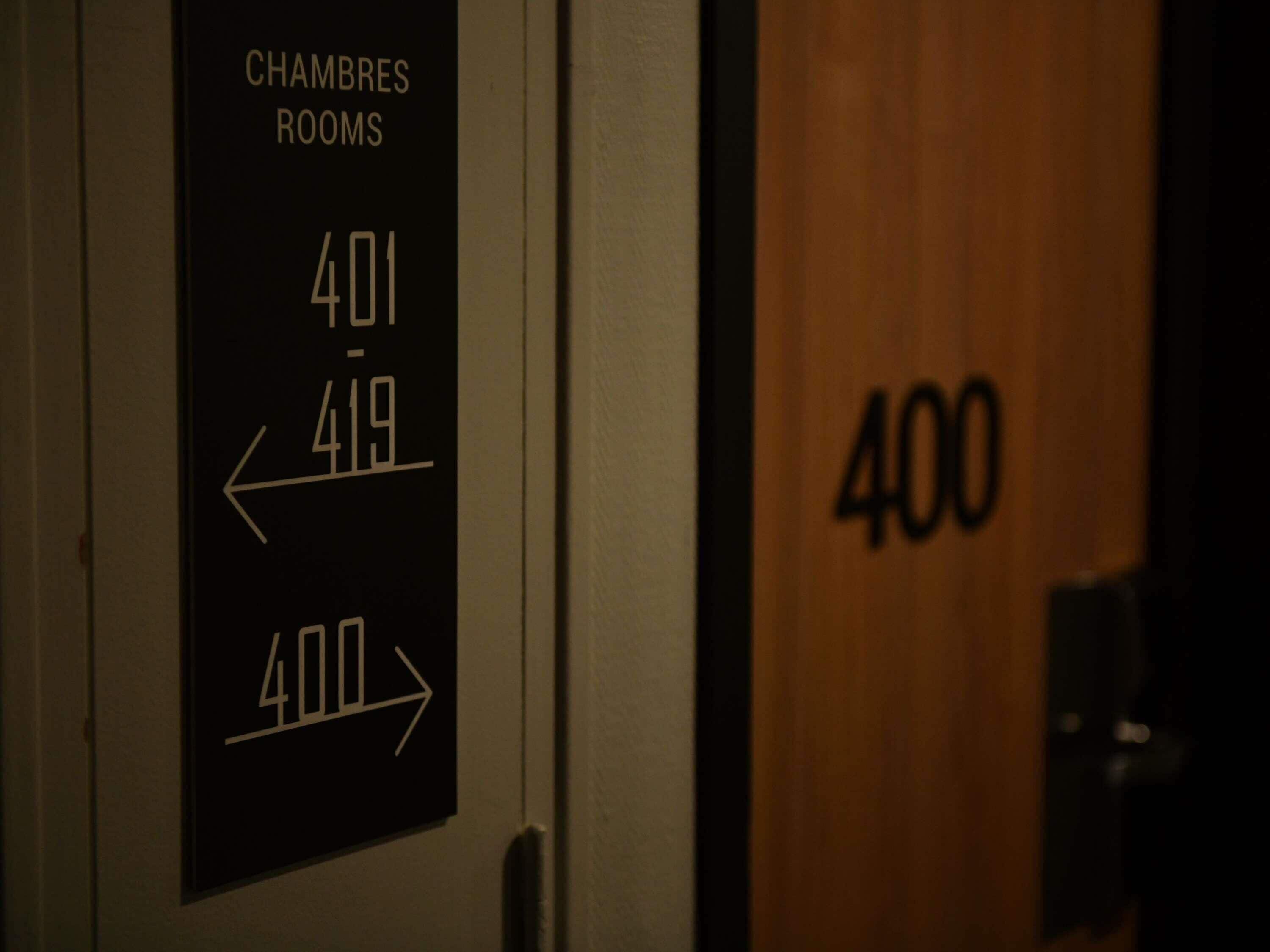 A hotel room sign with 'CHAMBERS ROOMS' and room numbers '401' and '419' with directional arrows.