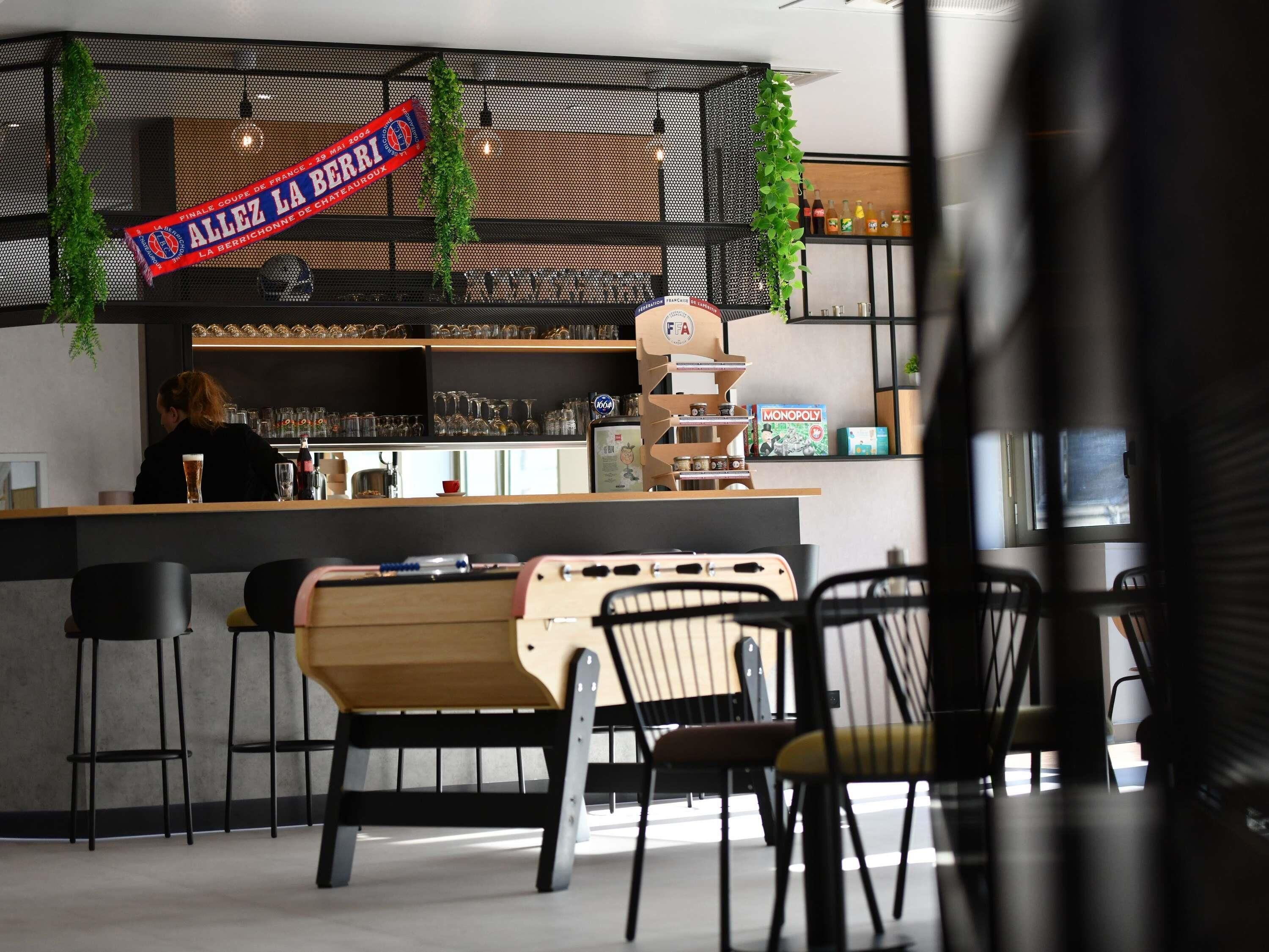 A bar area with a counter, stools, and a sign indicating a sports event.