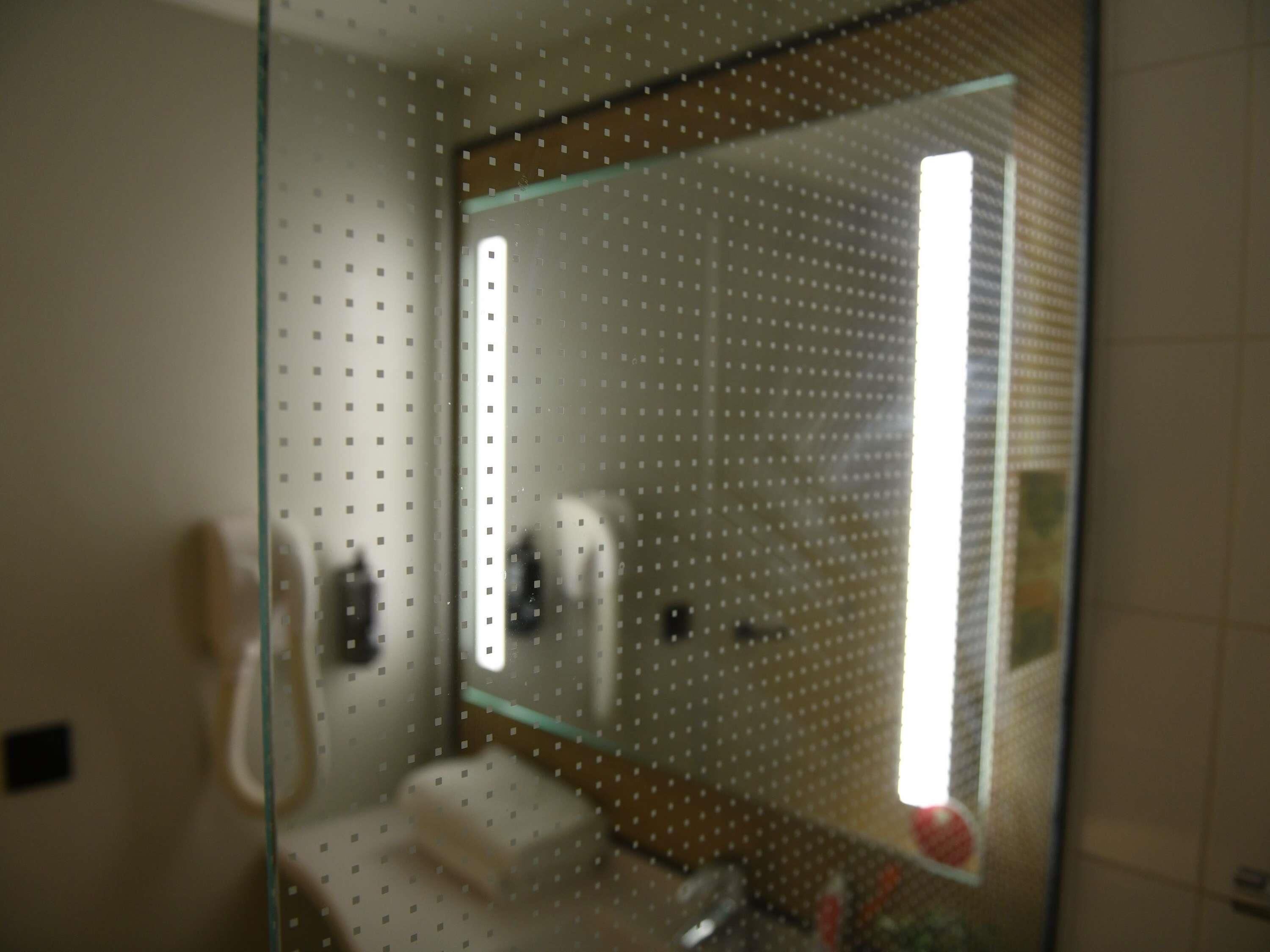 A bathroom with a glass partition, a toilet, and a sink.