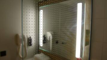 A bathroom with a glass partition, a toilet, and a sink.