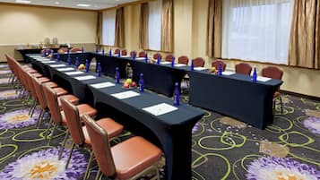A conference room with long tables, chairs, and water bottles.