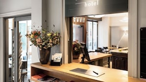 A hotel reception desk with a large vase of flowers, a sign reading "altstadt hotel", and a view into the room area. - Altstadt Hotel (Zürich)