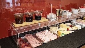 A buffet with various food items including meats, cheeses, and condiments. - Altstadt Hotel (Zürich)