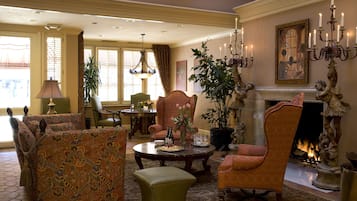 A traditional living room with a fireplace, comfortable seating, and a dining area.