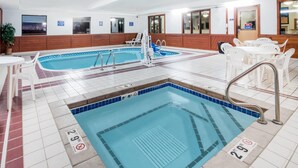 Une piscine intérieure à l’eau claire, avec des lignes indiquant la profondeur et un poste de surveillance pour les sauveteurs.