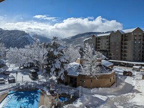 A hotel with a pool area, surrounded by snow-covered trees and mountains in the background. - Comfort Inn Near Vail Beaver Creek (Avon)
