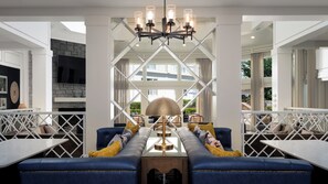 A modern interior with a central seating area, a chandelier, and a stone accent wall. - Hotel Indigo Atlanta-Vinings Ballpark Area by IHG (Atlanta)